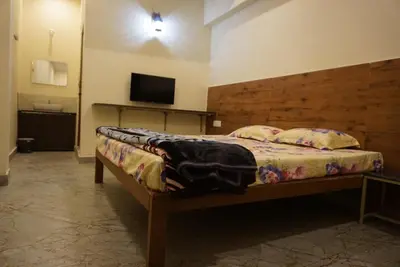 a bedroom with a bed and a flat screen tv at Signature by Rayhan in Vālpārai