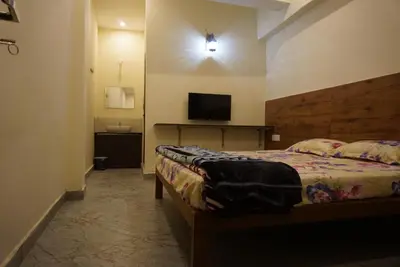 a bedroom with a bed and a flat screen tv at Signature by Rayhan in Vālpārai