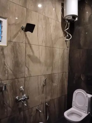 a bathroom with a toilet and a shower at Limra Farm House in Pollāchi