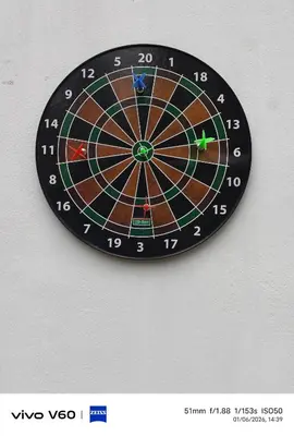 a dart board clock hanging on a wall at Limra Farm House in Pollāchi