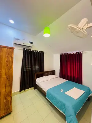 a bedroom with a bed and red curtains at 7FORT HOMESTAY Athirappilly in Athirappilly