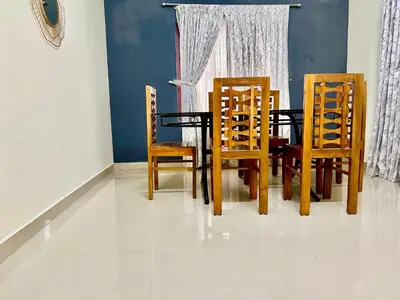 a dining room with a table and four chairs at Krishnakripa - Luxury Private Villa Near Guruvayoor Temple in Guruvāyūr