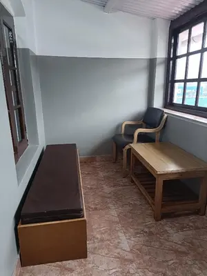 a room with a bench and a table and a chair at Trilan Cottages - Donnington Road in Kotagiri