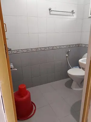 a bathroom with a toilet and a red trash can at Trilan Cottages - Donnington Road in Kotagiri