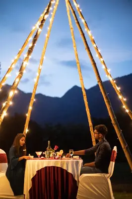 a man and woman sitting at a table in a tent at Avana Resort in Mettuppālaiyam