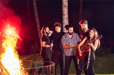 a group of men standing in front of a fire at Avana Resort in Mettuppālaiyam