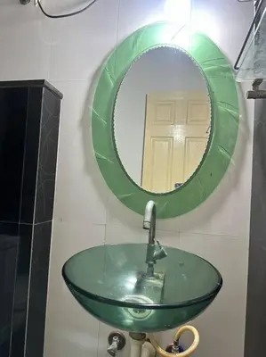 a bathroom with a green sink and a mirror at Aalayam, Villament & private pool in Mysore