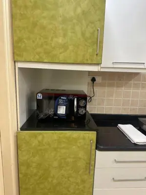 a kitchen with a toaster sitting on top of a counter at Aalayam, Villament & private pool in Mysore