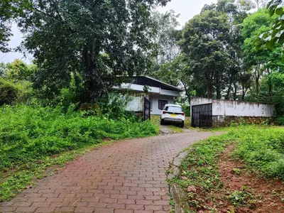 a brick road with a car parked in front of a house at Brahmagiri Homestay Serviced Villa in Thirunelli