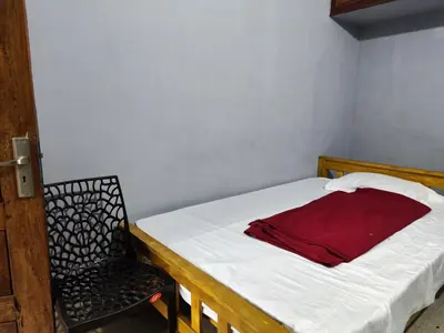 a small bedroom with a bed and a chair at Brahmagiri Homestay Serviced Villa in Thirunelli