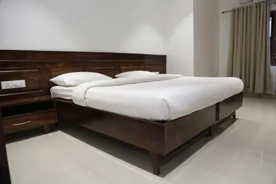 a bedroom with a large bed with white sheets at Wariyam Heritage in Trichūr