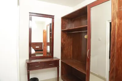 a dressing room with a mirror and a wooden cabinet at Wariyam Heritage in Trichūr