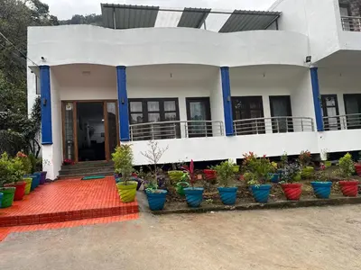 a house with colorful potted plants in front of it at BanyanThree in Kodaikānāl