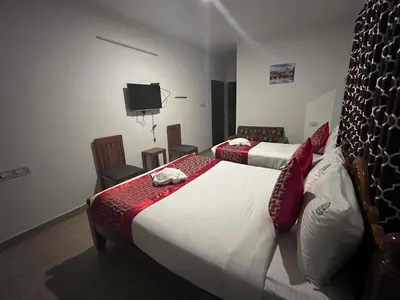 a hotel room with two beds and a tv at BanyanThree in Kodaikānāl