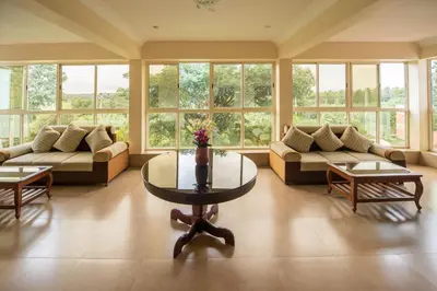 a large living room with couches and a table at Bota Royal in Kushālnagar