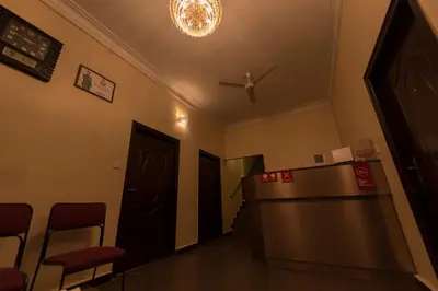 a waiting room with a table and chairs in a building at Bota Royal in Kushālnagar