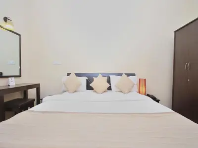 a bedroom with a large white bed with pillows at Bota Royal in Kushālnagar