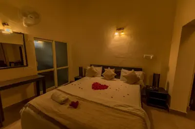 a bedroom with a bed with red flowers on it at Bota Royal in Kushālnagar