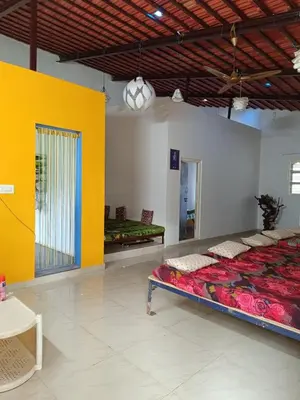 a large room with a bed and a yellow wall at Lilly Farm in Halgūr