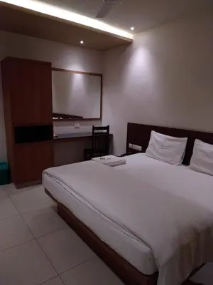 a bedroom with a large bed and a flat screen tv at Sri bhavan residency in Palakkad