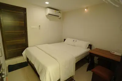 a small bedroom with a white bed and a desk at Port View Residency PVR in Nedumbassery
