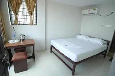 a small bedroom with a bed and a table at Port View Residency PVR in Nedumbassery