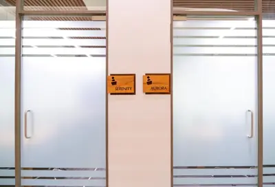 two white doors with signs on them in a room at 0484 Aero Lounge-Terminal 2 Cochin Airport Hotel in Nedumbassery