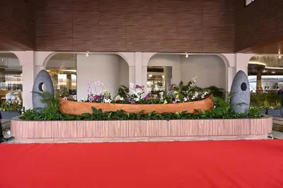 a display of flowers in a building with a red carpet at 0484 Aero Lounge-Terminal 2 Cochin Airport Hotel in Nedumbassery