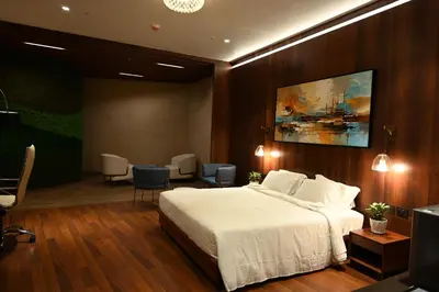 a hotel room with a bed and a waiting room at 0484 Aero Lounge-Terminal 2 Cochin Airport Hotel in Nedumbassery
