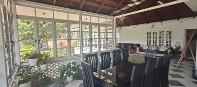 a room with chairs and tables and windows at Padikkal Bungalow in Vayittiri