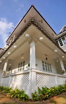 a white house with windows and plants at Padikkal Bungalow in Vayittiri