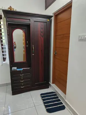 a hallway with a wooden door and a mirror at Krishnarpanam 2BHK villa in Guruvayoor- only for families in Guruvāyūr