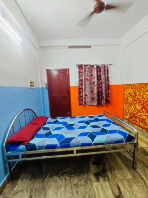 a bedroom with a bed with blue and orange walls at Omega Tourist Home in Trichūr