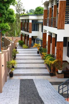 a walkway with potted plants in front of a building at Ecostay inn in Sultan Bathery