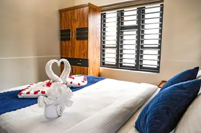 a bedroom with a bed with two white towels at Ecostay inn in Sultan Bathery