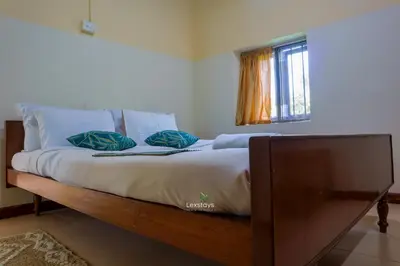 a bed with two pillows on it in a room at 42 Green Pastures By Lexstays -Tea Estate Experience in Coonoor