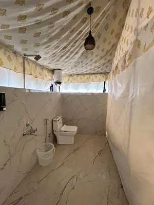 a bathroom with a sink and a toilet in a tent at TauSco Homestay & Campsite - Coorg in Madikeri