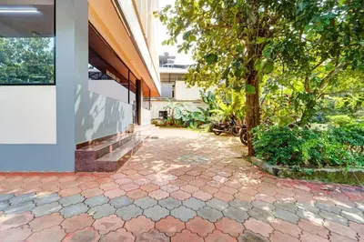 a courtyard with a tree next to a building at Super Hotel O Thrissur Near Thrissur Medical College in Trichūr