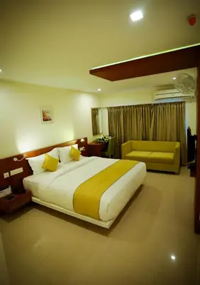 a bedroom with a large bed and a couch at hotel emperor in Sultan Bathery