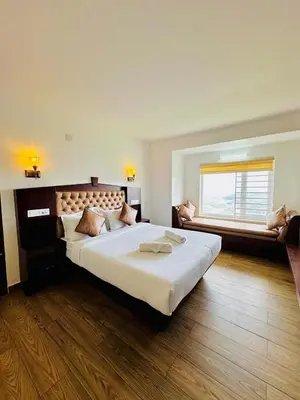 a large bedroom with a large bed and a window at Kanavu Valley View in Ooty