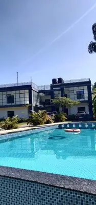 a large swimming pool in front of a building at Mountain Wings Resort in Vythiri