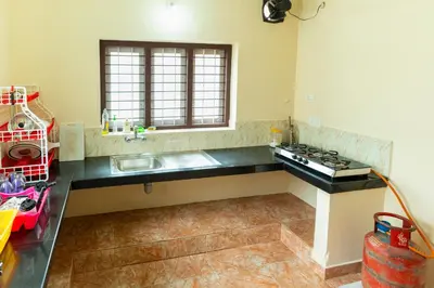 a kitchen with a sink and a stove in it at Be My Guest in Kozhikode