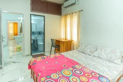 a bedroom with a bed with a pink comforter at Be My Guest in Kozhikode