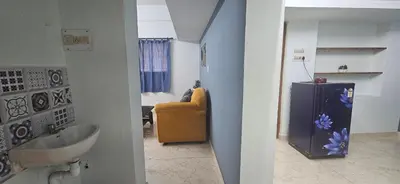 a bathroom with a sink and a yellow chair at SHIs Aathira 2bhk Heart of Coimbatore in Coimbatore