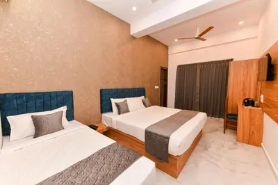 two beds in a hotel room at Hotel Shine International in Mysore