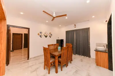 a dining room with a table and chairs at Hotel Shine International in Mysore