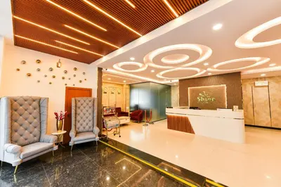 a lobby with two chairs and a reception desk at Hotel Shine International in Mysore