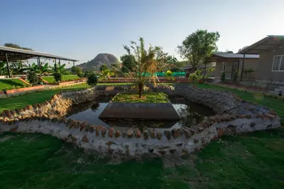 a garden with a pond and a tree in it at Valley Vibes in Rāmanagaram