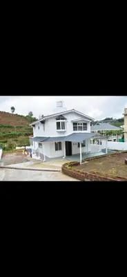 a large white house with a driveway in front of it at Attuvam Valley in Kodaikānāl