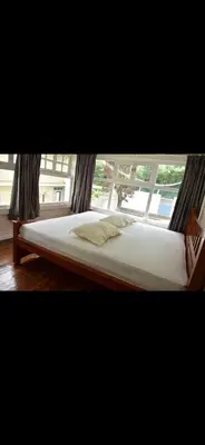 a bed in a room with a window at Attuvam Valley in Kodaikānāl